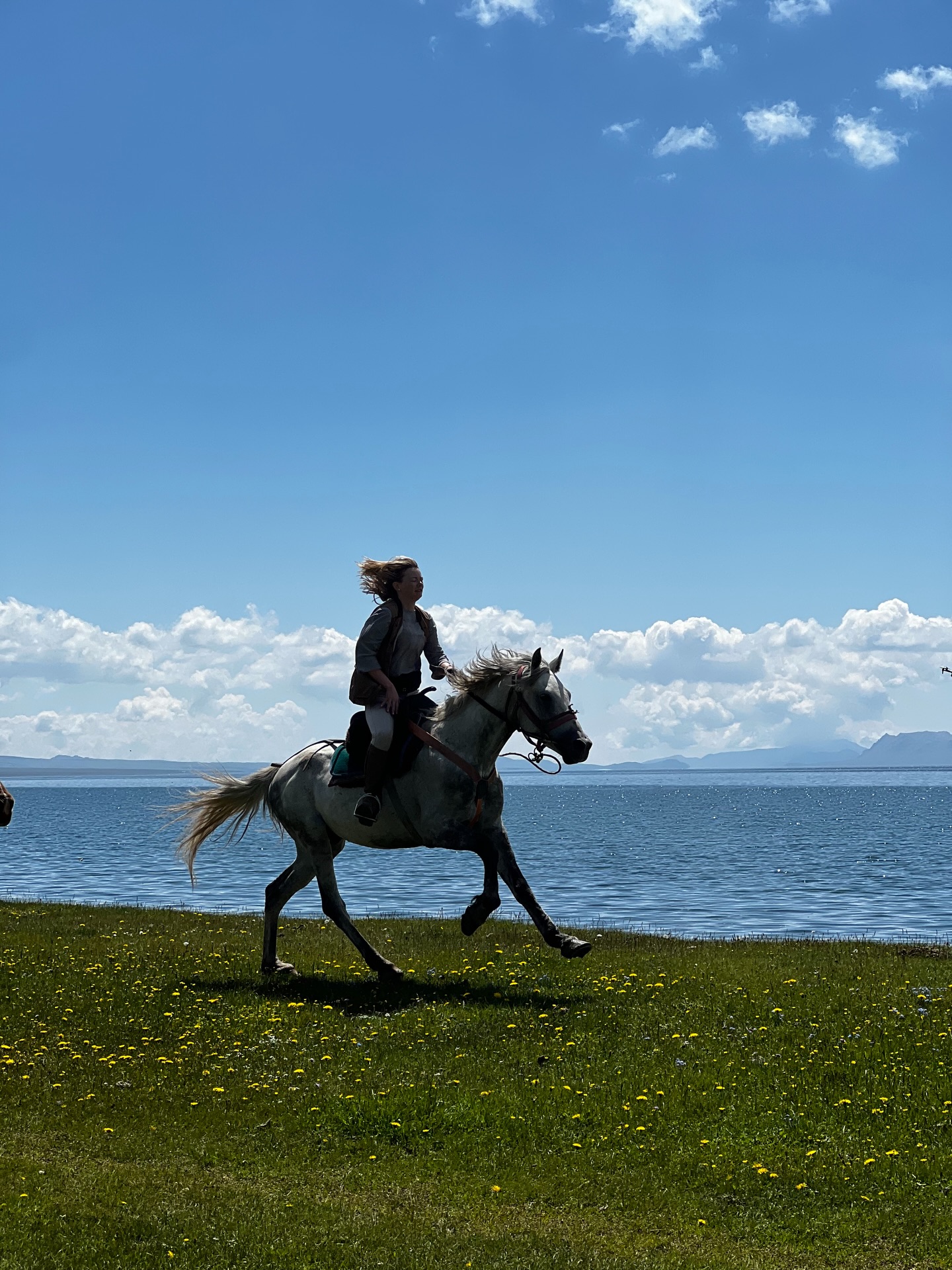 A rider cantering beside Song-Kol lake